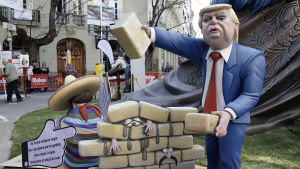 President Trumps planer på en mur mellan Mexiko och USA faller inte i god jord i Mexiko. En spansk träskulptur karrikerar Donald Trump som bygger en mur mot Mexiko av tegelstenar. Människor har fastnat mellan murens tegel.
