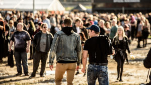 Trots ökat terrorhot i Finland ska det vara säkert att gå på festivaler i sommar. Två personer går mot en folkmassa på festivalen Rock Fest