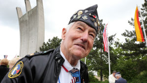 Den amerikanska piloten Johnny Macia invid ett monument för luftbron i Berlin. Fotografiet är taget den 12 maj 2014. Piloten Johnny Macia