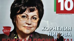 En man går förbi en valaffisch med Kornelia Nina som leder det Bulgariska socialistpartiet En man går förbi en valaffisch med Kornelia Nina som leder det Bulgariska socialistpartiet