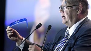 Soini visar upp sin kam. Timo Soini håller uppe en kam med bara en tand kvar