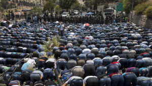 Palestinier ber utanför Gamla stadens murar i Jerusalem på fredagen 21.7.2017.