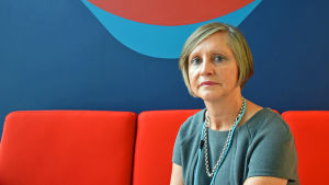 Ann-Christin Qvarnström-Obrey, psykolog och barnpsykoterapeut med fokus på trauma och kris Barnpsykologen Ann-Christin Qvarnström-Obrey mot en brokig vägg.