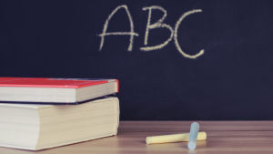 Det ska inte vara för mycket tomt rum i klasserna. Böcker och kritor framför en svart tavla med texten abc.