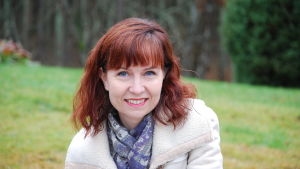 Radiodokumentaristi Katarina Blomqvist Nainen ulkona katsoo kameraa ja hymyilee