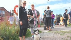 Sirke Bergman och Raseborgs informatör Marie Sandberg väntar tillsammans med hunden Lulle på att prideparaden i Hangö ska sätta igång.