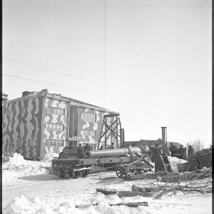 19.3.1940 Russarö. 9 tuuman tykin putkea nostetaan siirtovaunuun, takana kasarmi.