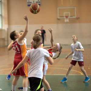 Skolbarn spelar basket i gymnastiksal