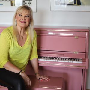 Mattila tog med sig det ljusröda pianot då hon 2007 sålde sin lägenhet i London. Nu är det till salu, men hon ger ingen garanti för att musikaliteten och sångrösten följer med till den nya ägaren. Karita Mattila sitter vid ett ljusrött piano.