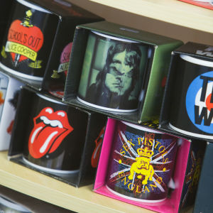 Bandmerchandise är det enklaste man kan erbjuda fansen. Kaffekoppar på med bandlogon butikshylla. Rolling Stones, Alice Cooper, Sex Pistols, ZZ Top, The Who-koppar.