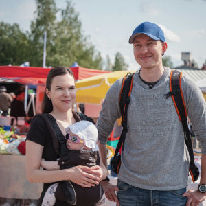– Det är jätteintressant att följa med, de gör ett fint jobb! Minja och Eero Pesonen är hemma i Ilomants och semestrar i hembygden. I bärselen sitter Lilja Pesonen. Nuoripari, naisella rintarepussa vauva aurinkolasit päässä