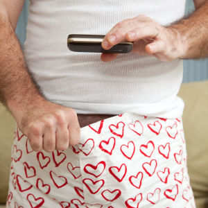Knäpp i kalsongen. En bild av en man som fotar ner i sina boxershorts, med en mobiltelefon.