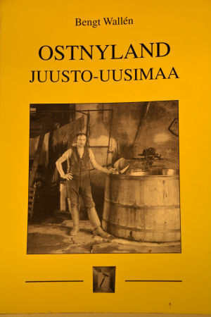Bengt Wallén har dokumenterat östnyländsk osthistoria i sin bok. Gul bokpärm med gammal bild på en man som ystar ost.