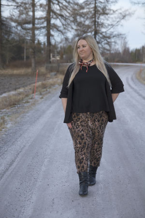 Nu går Heidi ut på promenader varje dag. En blond kvinna går på en grusväg ute på landet.