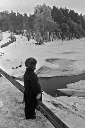 Lapsi sillalla, vesistö osittain jäässä, 1950-luku.