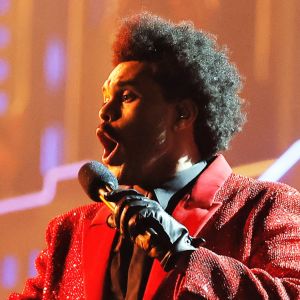 The Weeknd sjunger och dansar på scen. Han är klädd i en rödglittrig jacka.