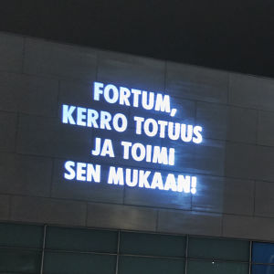 "Fortum berätta sanningen och agera enligt den!" projicerad text mot kiasmas vägg: Fortum kerro totuus