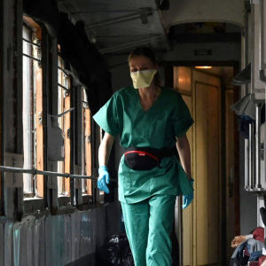 Lääkäri ja potilaita junavaunuun rakennetussa sairaalassa.