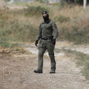 En person från de israeliska specialsäkerhetsstyrkorna letar efter fångarna som rymt på ett stort fält.
