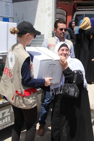 Utdelning av humanitär hjälp i östra Mosul. I de västra delarna av staden pågick ännu aktiva strider. Juli 2017. Mariette Hägglund delar ut en låda med förnödenheter till en kvinna i östra Mosul 2017.
