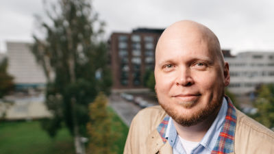 Kike Bertell står på en balkong i Västra Böle i Helsingfors