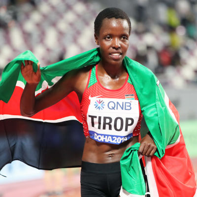 Agnes Tirop Kenian lippu harteillaan urheilusuorituksen jälkeen.
