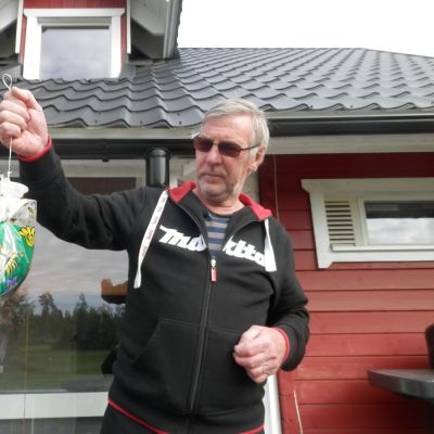 Jouko Liinamaa i Fäboda håller upp en flugfångare fylld med ett kilo flugor