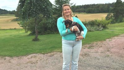 Kvinna som håller hund i famnen.