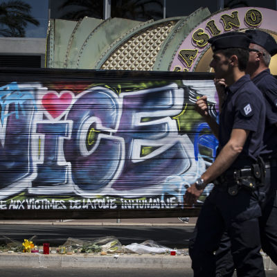Två poliser går förbi en graffitimålning som hedrar offren i attacken i Nice.