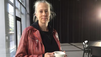 Kvinna med kopp kaffe i handen.