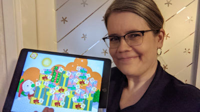 Pia Manns håller i en pekplatta med BUU-klubbens applikation.