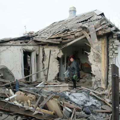En kvinna hämtar saker ur sitt sönderskjutna hus i byn Jasinovataja i Donetsk-regionen den 21 december. Byn kontrolleras av proryska rebeller.
