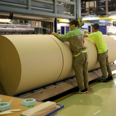 työntekijät teippaavat laminaattipaperirullia Kotkamillsin tehtaassa