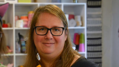 En kvinna med långt brunt hår och glasögon