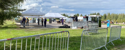 Ett konsertområde under uppbyggnad bakom metallstängsel.
