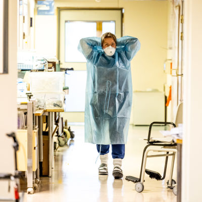 En sjukskötare tar på sig skyddsutrustning.