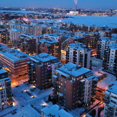 Vy över Drumsö i Helsingfors, i bakgrunden syns Gräsviken. En massa bostadshus med tända lampor en vinterkväll.
