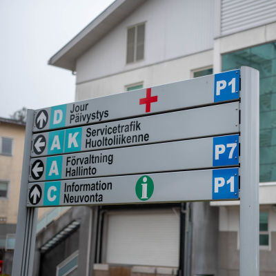 Ekenäs sjukhus sett från baksidan med en skylt i förgrunden