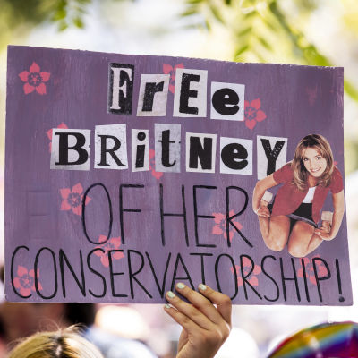 En person håller upp ett plakat under en demonstration för Britney Spears i juli 2021. På plakatet står "Free Britney of her conservatorship".