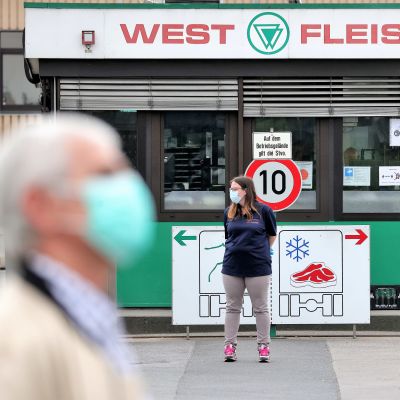 Människor i ansiktsmasker utanför livsmedelsföretaget Westfleisch i Hamm i Tyskland.