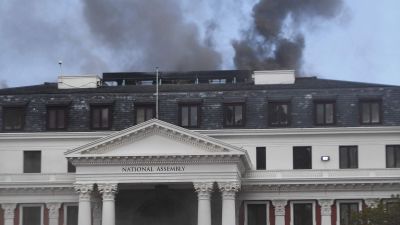 Parlamentsbyggnaden i Sydafrika brinner. Mörkgrå rök stiger från byggnaden.