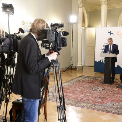Sauli Niinistö i Presidentens slott, håller presskonferens på långt avstånd från två tv-kameror