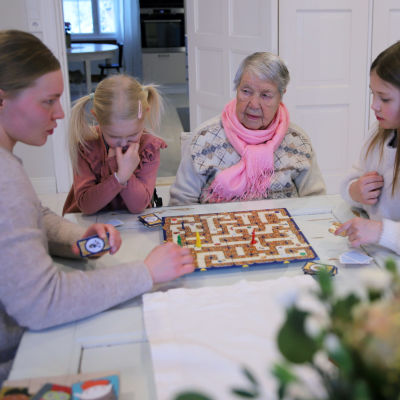 Elli Koponen pelaa lasten kanssa muistipeliä ikäihmisten perhekodissa Savonlinnassa. 