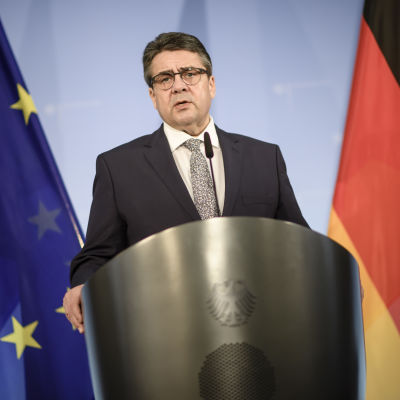 Sigmar Gabriel, Tysklands utrikesminister står mellan EU:s och Tysklands flaggor.