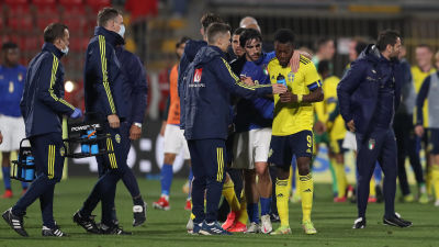 En hög med svenska och italienska ledare och spelare diskuterar efter en match.