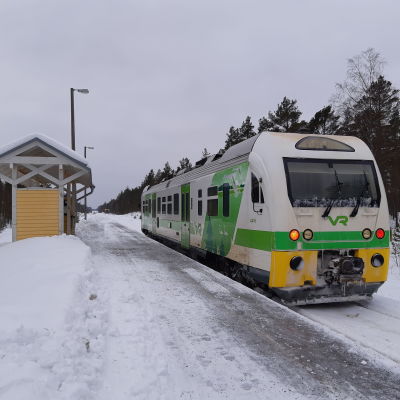 En grönvit rälsbuss på järnvägsspåret i Skogby.