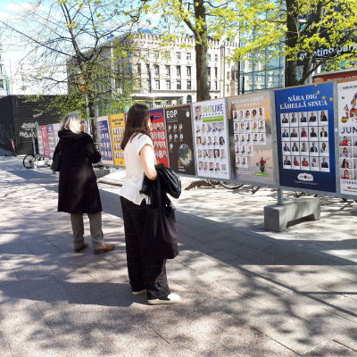 Personer ser på valreklami Helsingfors.