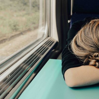 Väsynyt nainen junassa.