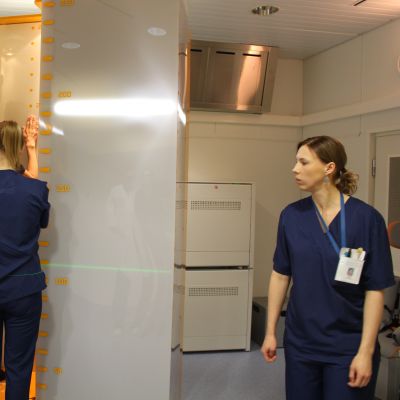 Patient står i ny röntgenapparat vid ÅUCS och får hjälp av två röntgenskötare. 