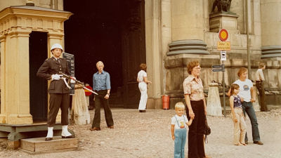 En bild från 70-talet där Petri håller i sin mammas hand utanför ett slott. I bakgrunden en vakt.